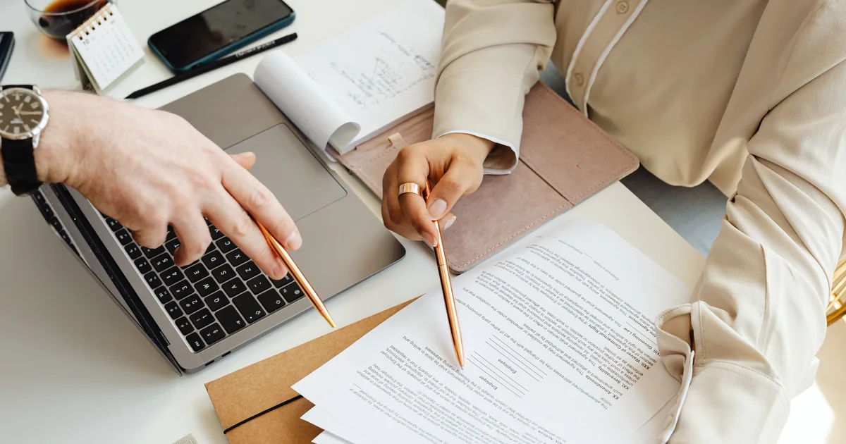 Printed invoices and a laptop on an office desk