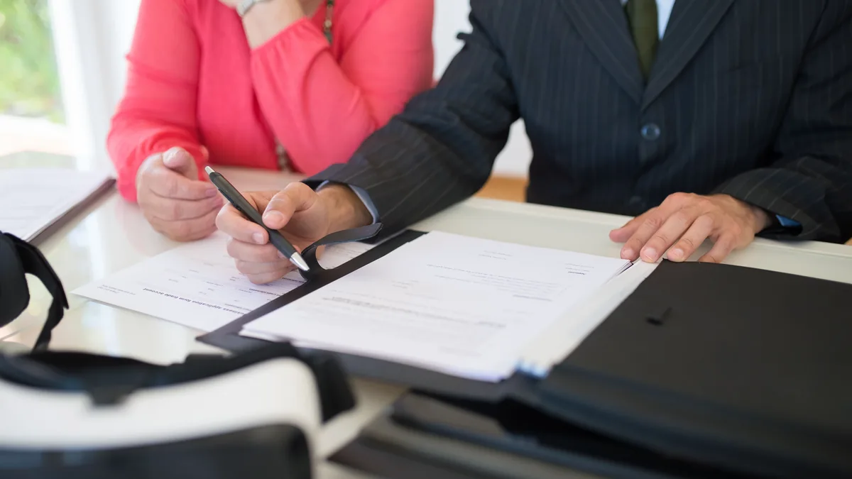 Close-up of hands signing a share transfer document